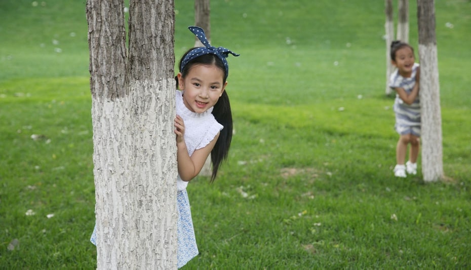 kids hiding behind trees